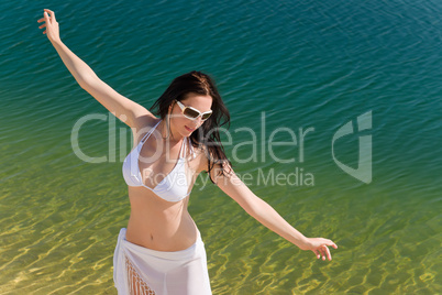 Summer young woman on seashore in bikini