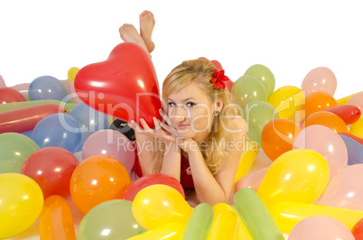 Junge Frau in einem Meer aus Luftballons