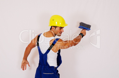 Bauarbeiter mit Helm streicht Wand an