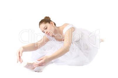 Ballerina macht Spagat im weißen Ballettköstüm