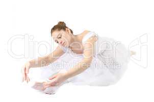 Ballerina macht Spagat im weißen Ballettköstüm