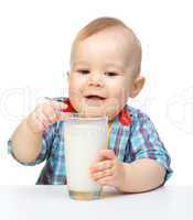 Cute little boy is holding big glass of milk