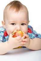 Little child is biting red apple and smile