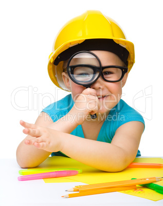 Cute little girl is looking through magnifier