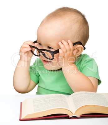 Little child play with book and glasses