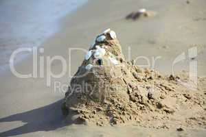Kleine Sandburg am Strand. Small sand castle at the beach.