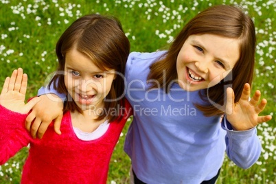 Two sisters waving