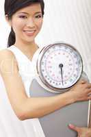 Oriental Asian Chinese Woman Holding Weighing Scales at Gym