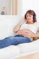 Portrait of a happy pregnant woman listening to music
