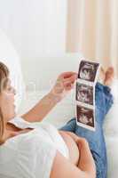 Good looking pregnant woman looking at a sonography