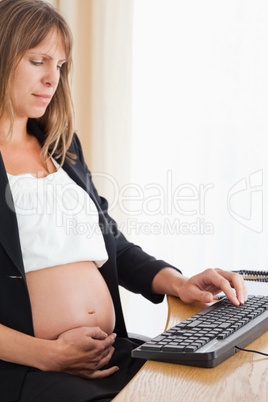 Pretty pregnant woman working with a computer