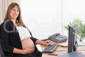 Cute pregnant woman working with a computer