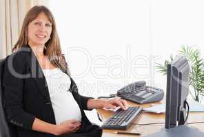 Gorgeous pregnant woman working with a computer