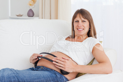 Happy pregnant woman with headphones on her belly