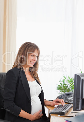 Attractive pregnant female working with a computer Attractive pregnant female working with a computer