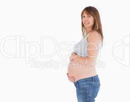 Side view of a beautiful pregnant woman caressing her belly whil