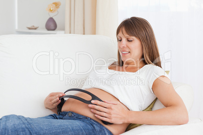 Close up of a pregnant woman with headphones on her tummy