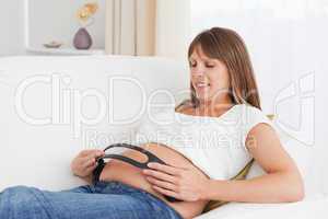 Close up of a pregnant woman with headphones on her tummy