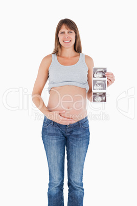 Beautiful pregnant woman showing an ultrasound scan while standi