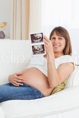 Portrait of a pregnant woman looking at her baby's ultrasound sc