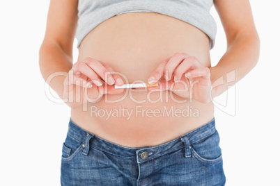 Pregnant woman holding a cigarette while standing