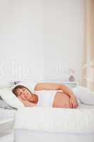 Good looking pregnant woman relaxing while lying on her bed