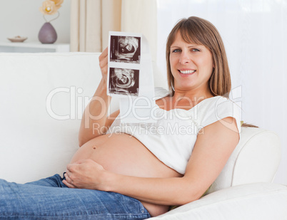 Close up of a pregnant woman holding her baby's ultrasound scan