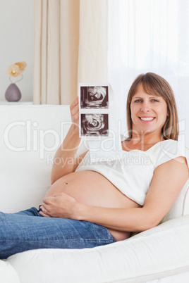 Portrait of a pregnant woman showing her baby's ultrasound scan