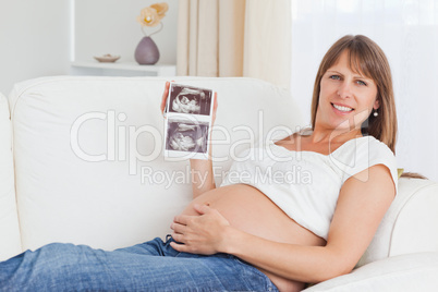 Pregnant woman showing her baby's ultrasound scan