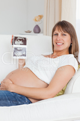 Close up of a pregnant woman showing her baby's ultrasound scan