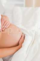 Close-up of a young pregnant woman lying on a bed