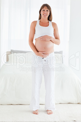 Beautiful pregnant female posing while standing