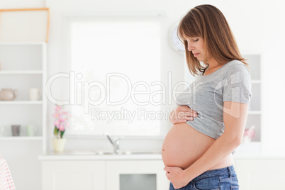 Attractive pregnant woman posing while caressing her belly