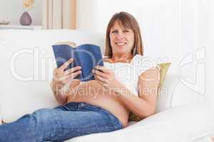 Happy pregnant woman reading a book