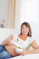 Portrait of a pregnant woman eating a salad