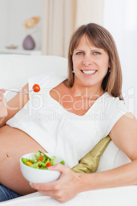 Portrait of a mother to be eating a salad