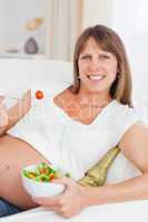 Portrait of a mother to be eating a salad