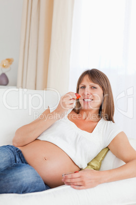 Beautiful pregnant woman eating strawberries