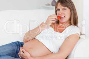 Charming pregnant woman eating strawberries
