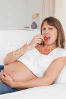 Attractive pregnant woman eating strawberries