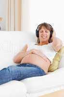Portrait of a pregnant woman listening to music