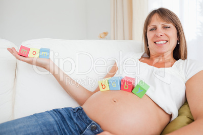 Attractive pregnant woman chilling out with toys