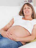 Charming pregnant woman posing while lying