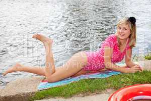 Junge Frau liegt am Fluss und sonnt sich 259