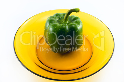 green pepper on a plate isolated on white