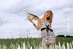Junge Frau mit Strohhut steht im Getreidefeld 396