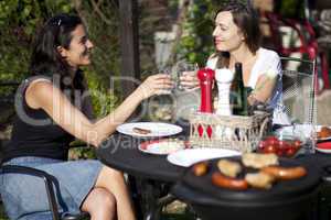 Zwei Frauen bei Gartenparty mit Grillen
