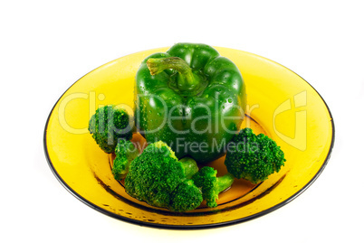 pepper and broccoli on a plate isolated on white