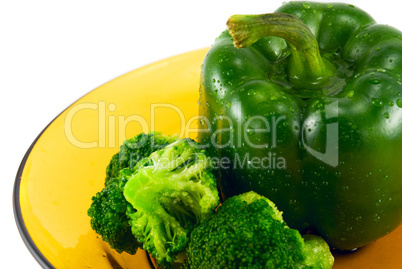 pepper and broccoli on a plate isolated on white