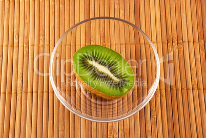 kiwi fruit in a glass bowl on a bamboo mat